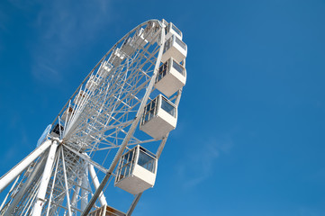 Ferris wheel on blue sky background.