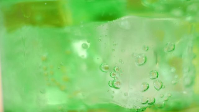 Air Bubbles Inside Glass of Sparkling Green Water. Fresh fizzy summer soda, green cocktail, healthy drink concept