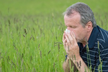 Middle aged man suffering from hay fever. Seasonal allergy problem.