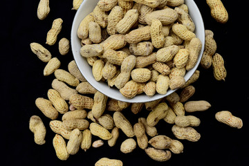 Peanuts on a plate with a blank black background