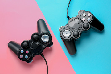 Modern game pads on color background