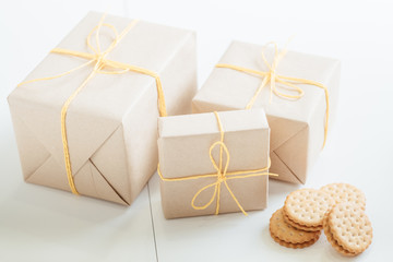 Homemade cookies. Bakery food delivery. Rustic paper mockup gift boxes tied with yellow cord. White background.