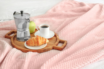 Tray with tasty breakfast on bed