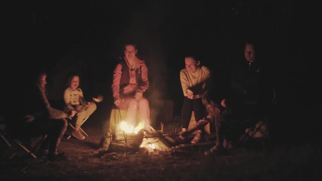 Family on a picnic near a campfire in the dark
