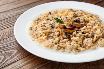 Plate with tasty risotto on wooden table