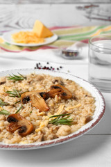 Plate with tasty risotto on white table