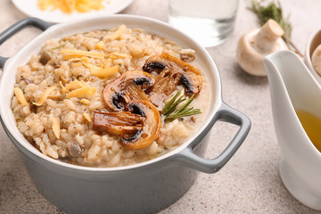 Pot with tasty risotto on table