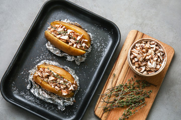 Plate with tasty stuffed potato on grey table