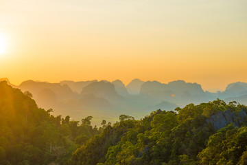 Beautiful landscape with dramatic sunset, tropical rainforest and steep mountain ridge on horizon. Krabi, Thailand - obrazy, fototapety, plakaty