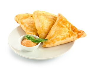 Delicious samosas with sauce on white background