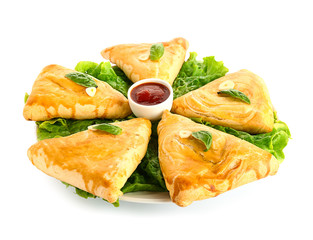 Delicious samosas with sauce on white background