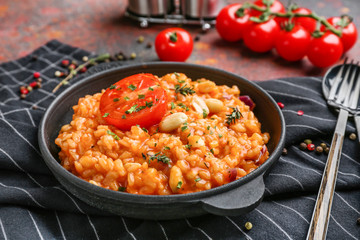 Frying pan with tasty risotto on table