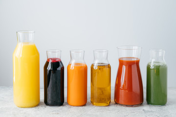 Refreshing summer drinks. Orange, carrot, apple, tomato, spinach and pomegranate juice in glass jars isolated over white background