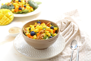 Bowl with tasty mango salad on light table