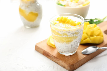 Glass of tasty mango dessert on white table