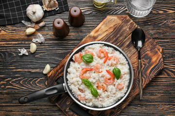 Frying pan with tasty risotto on wooden table