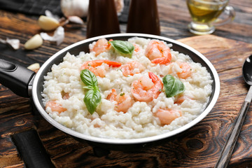 Frying pan with tasty risotto on table