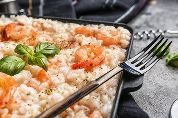 Frying pan with tasty risotto on table, closeup
