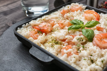 Frying pan with tasty risotto on table, closeup