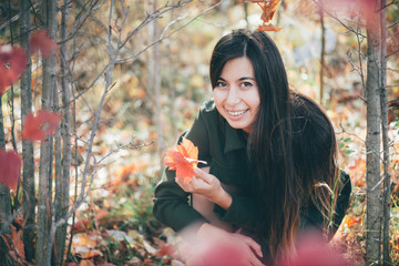 Female beauty portrait surrounded by vivid foliage. Dreamy beautiful girl with long natural black...