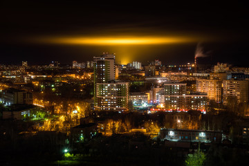 Naklejka premium Night cityscape with yellow glow the glow from the industrial greenhouses in the sky