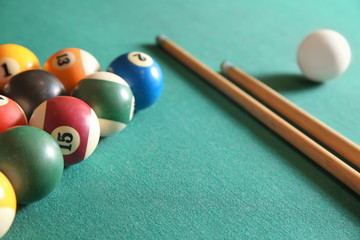 Billiard balls with cues on table