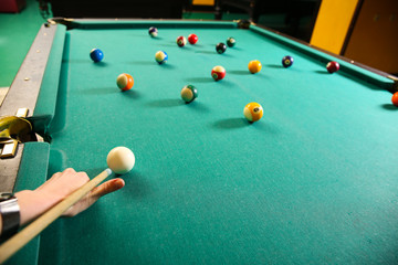 Young woman playing billiard in club