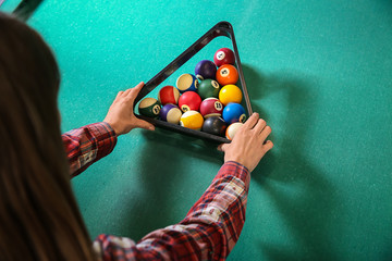 Young woman playing billiard in club