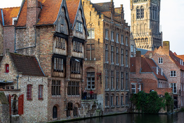 Obraz premium Bruges, Belgium - December 15, 2018: The Rozenhoedkaai (Quay of the Rosary) canal in Bruges with the classic medieval buildings and Belfry of Bruges in the background. Quay of Rosary in sunny day.