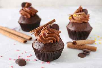 Tasty chocolate cupcakes on light background