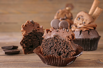 Tasty chocolate cupcake on wooden background