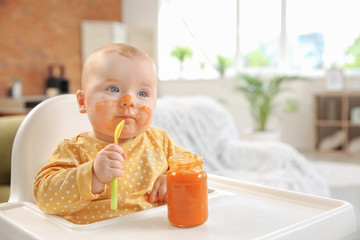 Cute little baby eating tasty food at home