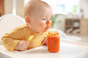 Cute little baby eating tasty food at home