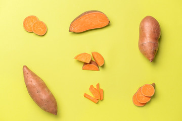 Fresh sweet potatoes on color background