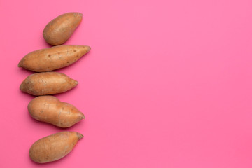 Obraz premium Fresh sweet potatoes on color background