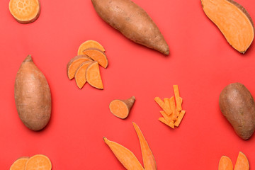 Fresh sweet potatoes on color background