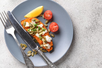 Baked sweet potato with cheese on plate