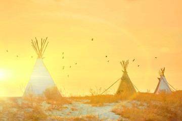teepees on the seashore. Architecture of Traditional american culture with sunset background. Alternative builds. Eco camping in summer. © baklykovadaria