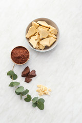 Composition with cocoa butter, powder and chocolate on light background
