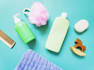 Wooden comb, liquid soap package, shampoo bottle, pink sponge and toy rocking horse. Beauty still life photography