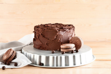 Stand with tasty chocolate cake on wooden table