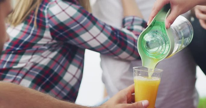 Happy millennial friends cheering at breakfast brunch meal in nature outdoor