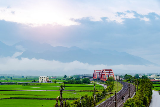 Landscape view of red bridge with rice filed at yuli Hualien Taiwan in rain.