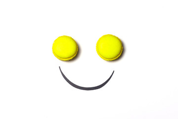 Smiley face concept. Smiley face made from macaroon on white background. Sweet smiley face metaphor. 