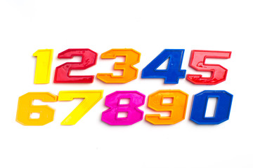 Heap of plastic colored arithmetic numbers close up.