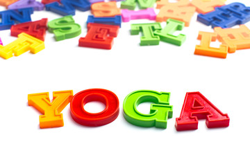 Heap of plastic colored alphabet letters close up. Yoga