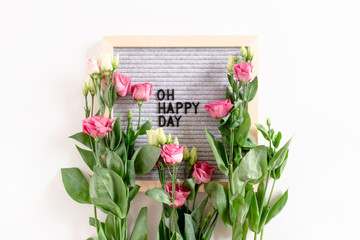 Quote Oh happy day. Flatlay with letter .board and eustoma flowers on white background