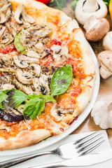 From above shot of cheesy crispy pizza with mushrooms