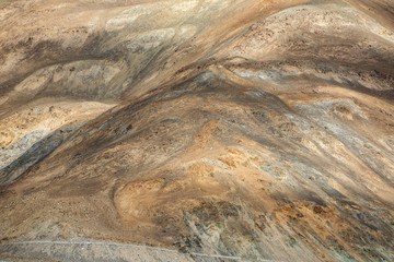 Little car on the high altitude road in Ladakh with huge Himalaya mountains at background