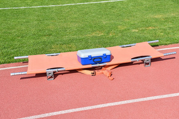 Strecher and medical kit next to the soccer field © majorosl66
